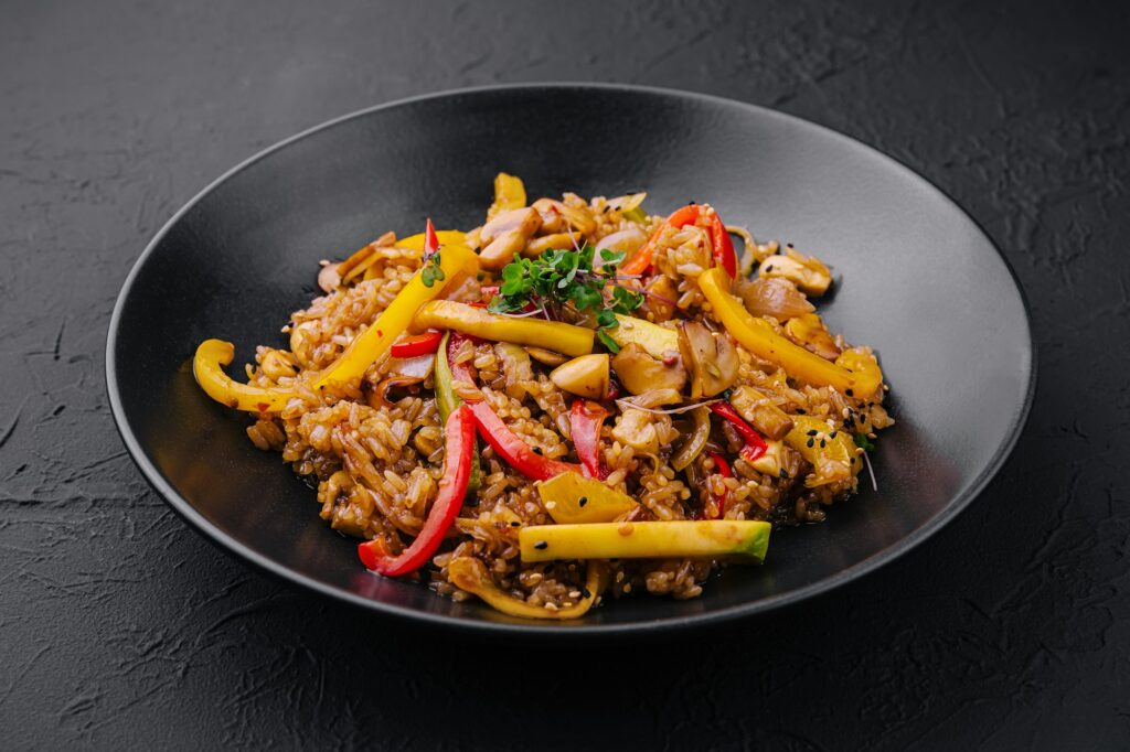 Chinese Fried Rice Nutrition Facts: What You Need to Know 2 Chinese fried rice with vegetables on black plate