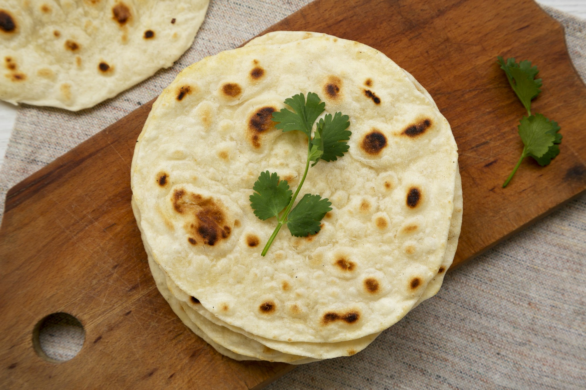 Homemade Roti Chapati Flatbread on a rustic wooden board, top view.